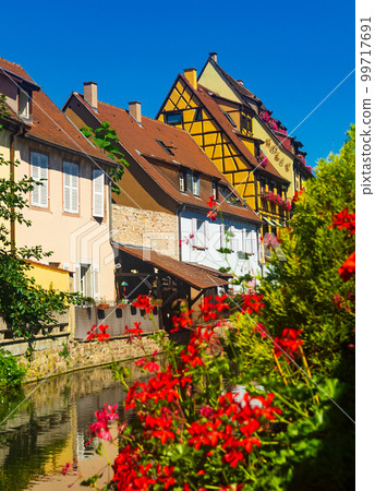 Scenic cityscape of Colmar on banks of canal on summer day, France 99717691