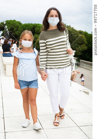 Portrait of mother and daughter in protective mask on the observation deck of European city 99717708