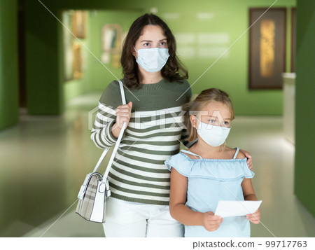 Woman with daughter in medical masks in museum of arts 99717763