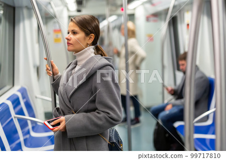 Young woman traveling in subway car Young woman traveling in subway car 99717810