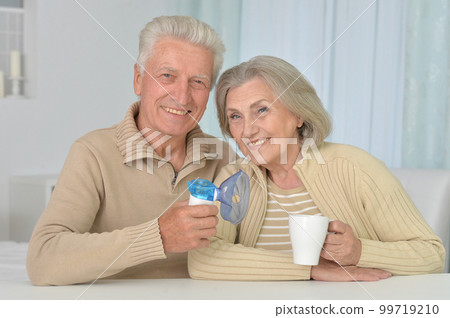 Portrait of old man with inhaler and woman at home Portrait of old man with inhaler and woman at home 99719210