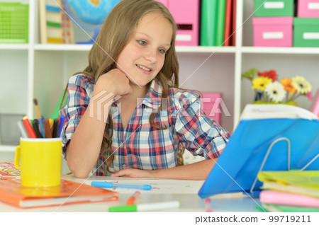 little girl studying at home at the table little girl studying at home at the table 99719211