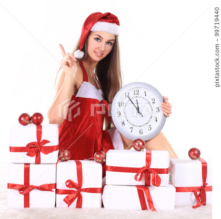 beautiful young woman in Christmas suit with a clock sitting on 99719440