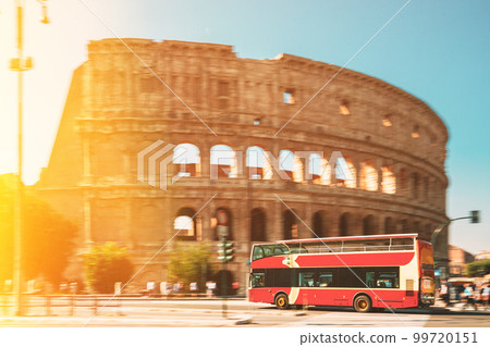 Rome, Italy. Colosseum. Glare Light On Red Hop On Hop Off Touristic Bus For Sightseeing Near Flavian Amphitheatre. Famous World Unesco Landmark. Highlight View. Scenic View Bright Sunbeams. Zeitgeist Rome, Italy. Colosseum. Glare Light On Red Hop On Hop Off Touristic Bus For Sightseeing Near Flavian Amphitheatre. Famous World Unesco Landmark. Highlight View. Scenic View Bright Sunbeams. Zeitgeist 99720151