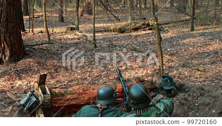 German Wehrmacht Infantry Soldier In World War II prepare for Shooting machine gun from Forest entrenchment. reload weapon German Wehrmacht Infantry Soldier In World War II prepare for Shooting machine gun from Forest entrenchment. reload weapon 99720160