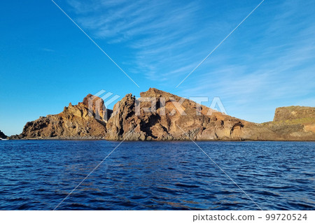 Small islands in the ocean. View of the red rocks of the mountain. 99720524