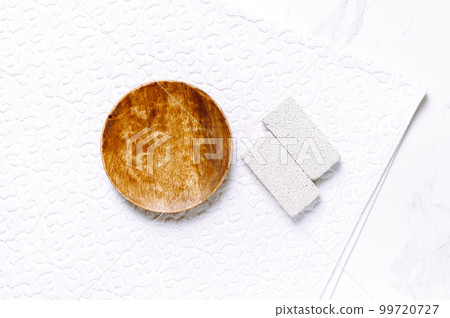 Minimalist composition for beauty skin care product presentation made with mockup wooden pedestal and pumice stones on a white towel. Minimalist composition for beauty skin care product presentation made with mockup wooden pedestal and pumice stones on a white towel. 99720727