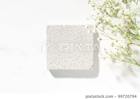 Summer minimal scene for beauty cosmetic product presentation made with white porous pumice stone and wild flowers on white background. Top view. Studio photography. Summer minimal scene for beauty cosmetic product presentation made with white porous pumice stone and wild flowers on white background. Top view. Studio photography. 99720794