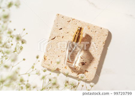 Summer fragrance concept made with perfume bottle on travertine plate in sunlight. Summer fragrance concept made with perfume bottle on travertine plate in sunlight. 99720799
