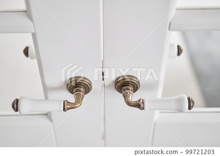 Old-style door, white - handle close up. The interior of a bright living room in a modern apartment. Old-style door, white - handle close up. The interior of a bright living room in a modern apartment. 99721203