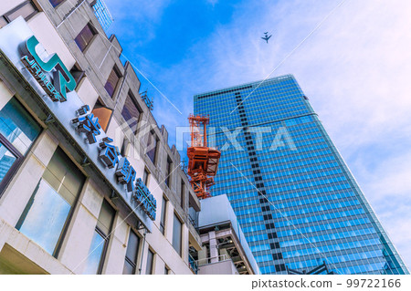 日本東京的城市景觀：一架飛機飛過正在拆除的澀谷站，以及重建中的櫻丘口。航空旅行需求恢復 = 3 月 1 日 99722166