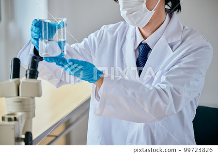一個穿白大褂的年輕人在做實驗 99723826