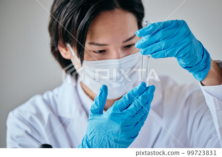 一個穿白大褂的年輕人在做實驗 一個穿白大褂的年輕人在做實驗 99723831