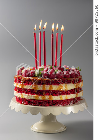 birthday cake on a stand with candles 99725360