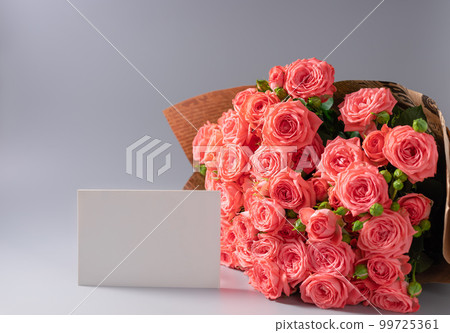pink roses bouquet in vintage craft paper and blank white card 99725361