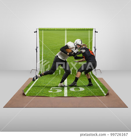 Attack. Competition. Two men, professional american football players in uniform playing over sports playground background. Concept of sport 99726167