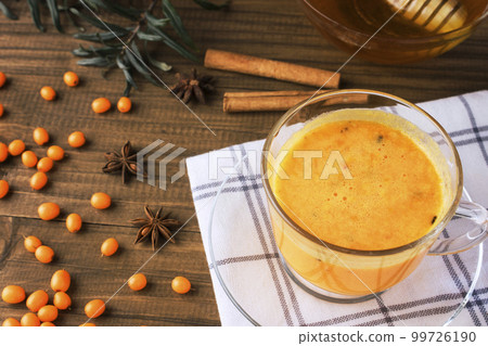 Tea of sea-buckthorn berries on dark wooden background Tea of sea-buckthorn berries on dark wooden background 99726190