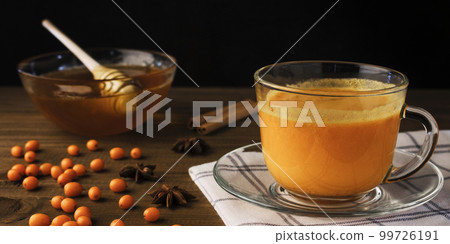Tea of sea-buckthorn berries on dark wooden background Tea of sea-buckthorn berries on dark wooden background 99726191