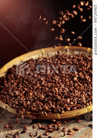Medium-roasted coffee beans are poured into a basket. 99726465