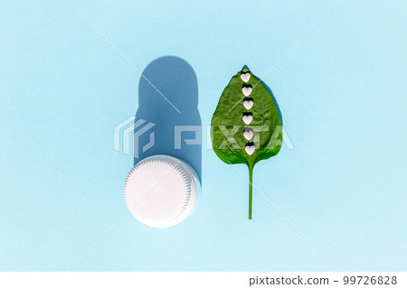 White pills on green plantain leaf and of bottle on blue background. Homeopathy, naturopathy, nutraceuticals and healthcare concept. Top view Flat lay White pills on green plantain leaf and of bottle on blue background. Homeopathy, naturopathy, nutraceuticals and healthcare concept. Top view Flat lay 99726828