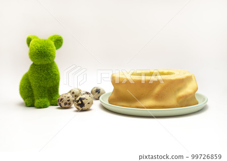 Green hare, rabbit with quail eggs and delicious baumkuchen, Sakotis ,sekacz pie on white background. Easter concept. Horizontal plane Green hare, rabbit with quail eggs and delicious baumkuchen, Sakotis ,sekacz pie on white background. Easter concept. Horizontal plane 99726859