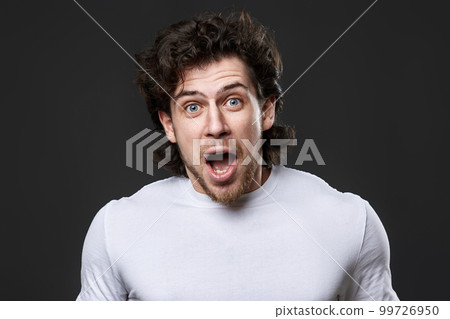 surprised young bearded man on gray backround 99726950