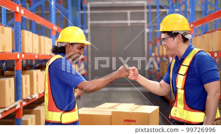 Happy Asian warehouse workers making a hand tagging together and greeting. Happy Asian warehouse workers making a hand tagging together and greeting. 99726996