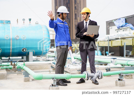 Professional Asian foreman and construction manager talking - discussing about building structure plant together. Businessman and construction engineer having a discussion. 99727137