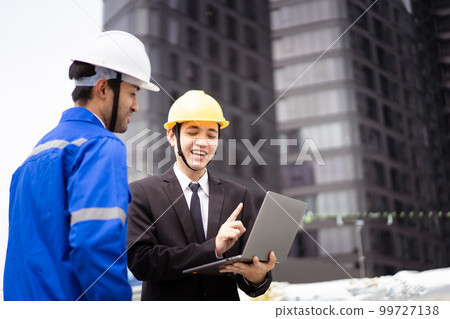 Professional Asian foreman and construction manager talking - discussing about building structure plant together. Businessman and construction engineer having a discussion. 99727138