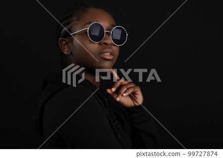 Cool african woman sitting with dark skin wearing round sunglasses Cool african woman sitting with dark skin wearing round sunglasses 99727874