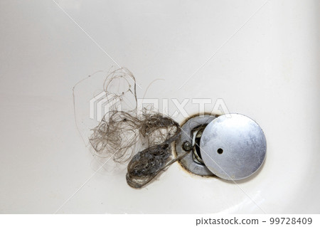 Shower drain is clogged with hair, Hair pile loss in a bathroom after wash hair in shower, cleaning bathroom and removing hair top view 99728409