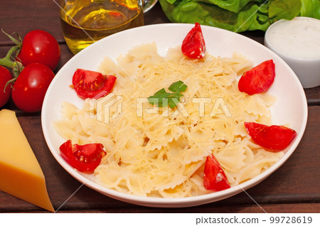 Pasta bows with tomatoes and parmesan cheese 99728619