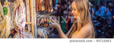 Mom and son travelers choose souvenirs in the market at Ubud in Bali, Indonesia BANNER, LONG FORMAT 99728863