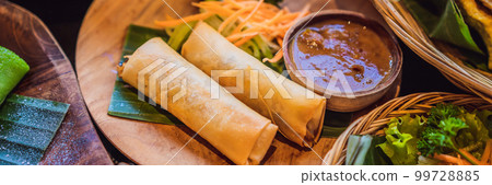 Fried spring rolls served with salad and sauce. Traditional Indonesian and Asian dish BANNER, LONG FORMAT 99728885