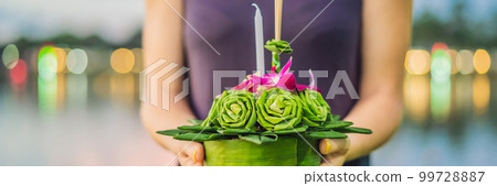 A female tourist holds the Loy Krathong in her hands and is about to launch it into the water. Loy Krathong festival, People buy flowers and candle to light and float on water to celebrate the Loy A female tourist holds the Loy Krathong in her hands and is about to launch it into the water. Loy Krathong festival, People buy flowers and candle to light and float on water to celebrate the Loy 99728887