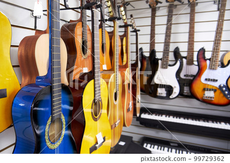 Various acoustic six-string guitars in a music store 99729362