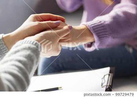 Close therapist holding clipboard, touching patients hands Close therapist holding clipboard, touching patients hands 99729479