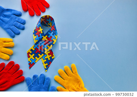Word Autism Awareness day. Autism Awareness Ribbon and Puzzle cubes on blue background. 99730032