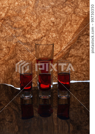 Still life with glassware with liquid on a reflective surface Still life with glassware with liquid on a reflective surface 99730350