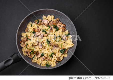 Delicious farfalle pasta with mushrooms, cheese and spinach with spices Delicious farfalle pasta with mushrooms, cheese and spinach with spices 99730822