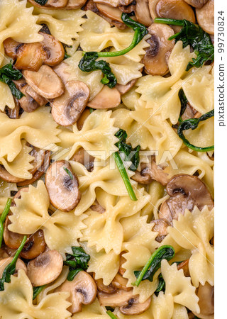 Delicious farfalle pasta with mushrooms, cheese and spinach with spices Delicious farfalle pasta with mushrooms, cheese and spinach with spices 99730824