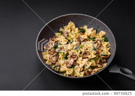 Delicious farfalle pasta with mushrooms, cheese and spinach with spices Delicious farfalle pasta with mushrooms, cheese and spinach with spices 99730825