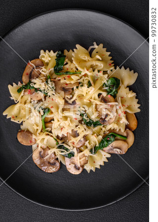 Delicious farfalle pasta with mushrooms, cheese and spinach with spices 99730832