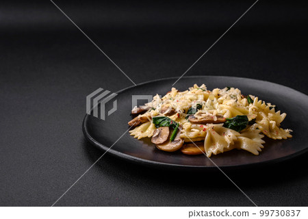 Delicious farfalle pasta with mushrooms, cheese and spinach with spices 99730837