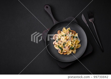 Delicious farfalle pasta with mushrooms, cheese and spinach with spices Delicious farfalle pasta with mushrooms, cheese and spinach with spices 99730842