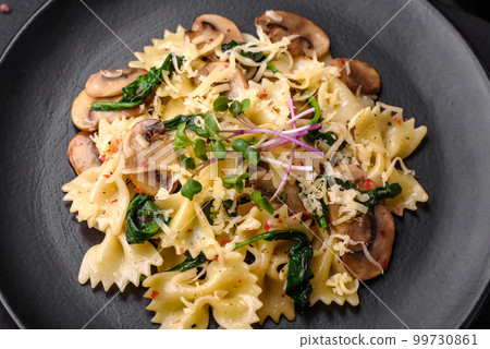 Delicious farfalle pasta with mushrooms, cheese and spinach with spices 99730861