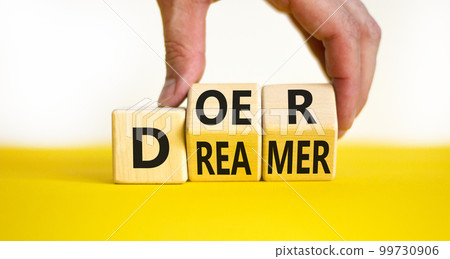 Doer or dreamer symbol. Concept words Doer or dreamer on wooden cubes. Businessman hand. Beautiful yellow table white background. Business and doer or dreamer concept. Copy space. Doer or dreamer symbol. Concept words Doer or dreamer on wooden cubes. Businessman hand. Beautiful yellow table white background. Business and doer or dreamer concept. Copy space. 99730906