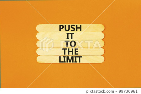 Push it to the limit symbol. Concept words Push it to the limit on wooden stick. Beautiful orange table orange background. Business push it to the limit concept. Copy space. 99730961