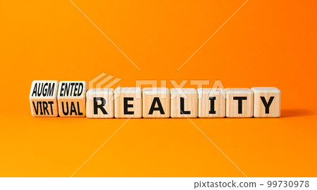 Augmented or virtual reality symbol. Concept words Augmented reality Virtual reality on wooden cubes. Beautiful orange table orange background. Business augmented virtual reality concept. Copy space. 99730978