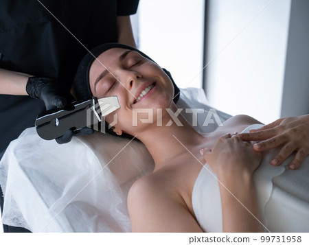 Woman on ultrasonic cleaning procedure. Hardware cosmetology. Woman on ultrasonic cleaning procedure. Hardware cosmetology. 99731958